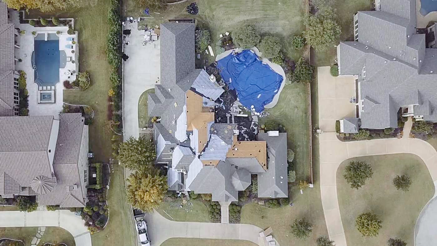 Overhead view of a roof replacement in progress with the decking exposed